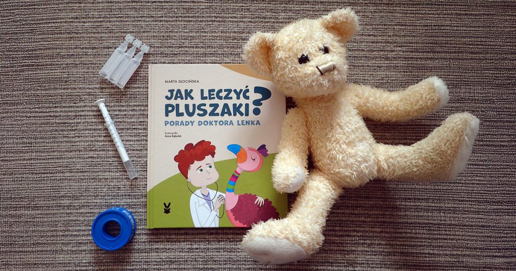 Książka „Jak leczyć pluszaki?” i rozrzucone dookoła zabawki